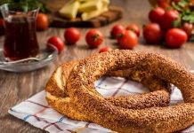Simit ve Açma Kültürü Şehir Hayatında Değişmeyen Lezzetler Türkiye’de sokak lezzetleri denildiğinde akla gelen ilk tatlar arasında simit ve açma yer alır. Günün her saatinde ulaşılabilen bu iki hamur işi, yalnızca pratik bir atıştırmalık olmanın ötesinde, şehir yaşamının ritmini belirleyen önemli unsurlardan biri olarak görülür. Sabah işe yetişmeye çalışan bir memurun elinde, okul yolunda koşan bir öğrencinin çantasında ya da sahil kenarında çay eşliğinde tüketilen bu lezzetler, toplumsal hafızanın da güçlü bir parçasıdır. Konulu bir haber görseli.